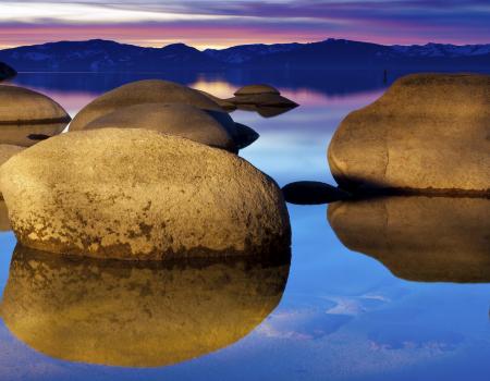 large boulders on the lake at sunset